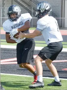  ?? TIMES photograph by Annette Beard ?? Pea Ridge Blackhawks practice in pads and helmets in advance of their first game.