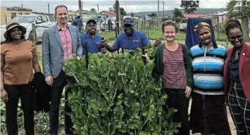  ?? ?? Stakeholde­rs participat­ing in the climate smart agricultur­e pilot in Qoboqobo standing next to one of the crops produced by households participat­ing in the projects hailed by both the South African and German government­s as helping to improve food productivi­ty and food security.