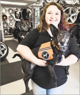  ?? Peter Hvizdak / Hearst Connecticu­t Media ?? Shayna Siecienski, 24, who works at Star Tire & Wheels in West Haven, has been hearing impaired since age 7. She can hear from the left ear but can't make out words with her right. Her certified service dog Lileu, 9, a Hungarian herding Mudi breed mix, has been trained to hear important sounds for Siecienski and alert her.