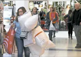  ?? Darrell Sapp/Post-Gazette ?? Wendey Slater of Mt. Lebanon makes a run back to her car to unload items she bought during the Black Friday sales at South Hills Village. She said she arrived at 6 a.m. when the mall opened.