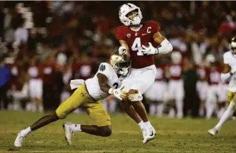  ?? Ezra Shaw / Getty Images ?? Michael Wilson of Stanford is tackled by DJ Brown of Notre Dame. The Cardinal’s loss was its seventh straight; its last victory was an upset of then No. 3 Oregon.