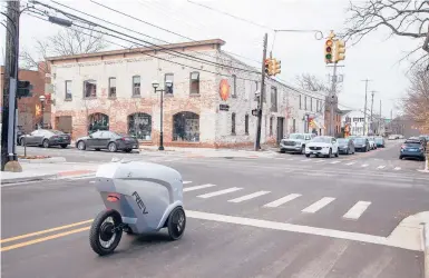  ?? MANDI WRIGHT/DETROIT FREE PRESS ?? Michigan-based Refraction AI has developed an autonomous delivery robot. The first generation Rev1 waits at a red light in Ann Arbor, Michigan, while delivering sandwiches in January. The pandemic has spurred an increase in automation.