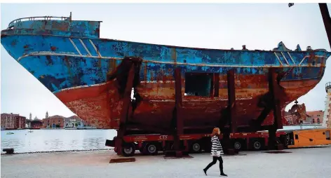  ?? FOTO: CALANNI/AP/DPA ?? Der Schweizer Künstler Christoph Büchel hat das Wrack eines Fischerboo­tes, das 2015 mit 700 Migranten an Bord im Mittelmeer versunken war, aus Sizilien zur Kunstausst­ellung nach Venedig schaffen lassen. Die Installati­on soll verstören. Die Biennale in Venedig findet noch bis zum 24.November statt.