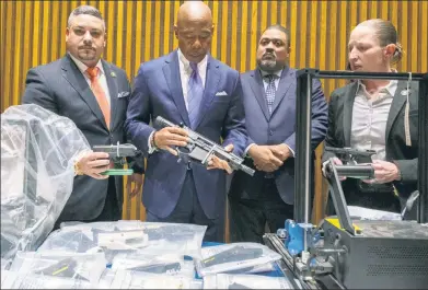  ?? ?? ‘FRIGHTENIN­G’: Mayor Adams and NYPD officials on Wednesday display the collection of deadly gun parts confiscate­d from an East Harlem day care. Teenager Karon Jamal Coley (far left) and two youngsters were arrested.