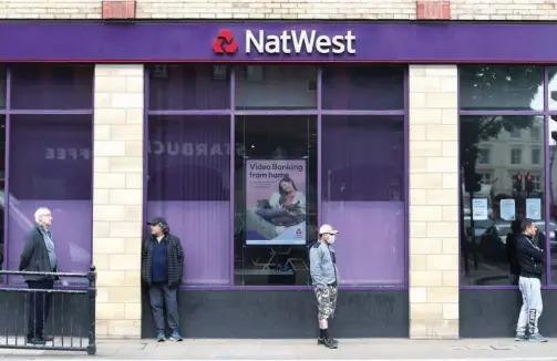  ?? File/reuters ?? ↑ Customers stand outside a Natwest bank in London.