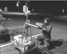  ?? ARIZONA STATE UNIVERSITY ?? ARIZONA STATE UNIVERSITY STUDENT AARON MEHNER prepares a device that will measure the heat given off from Phoenix streets on Sept. 12.