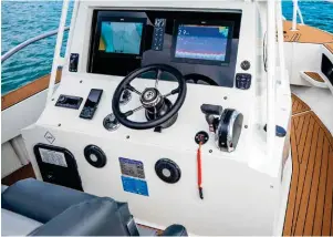  ??  ?? ABOVE The console is wide and deep, offering good protection and ample space for instrument­s. The flexible solar panel on the targa roof helps with battery management and the well-designed transom is a joy to fish from.