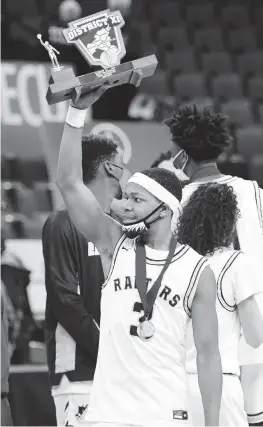  ?? RICK KINTZEL/THE MORNING CALL ?? Executive Charter’s Jalil Schenck holds the District 11 3A championsh­ip trophy last week after the Raptors defeated Notre Dame 81-68 at PPL Center in Allentown.