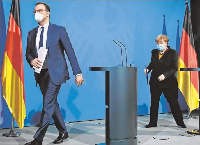  ?? EFE ?? El ministro de Salud alemán, Jens Spahn, y detrás, la canciller, Angela Merkel