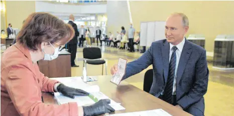  ?? FOTO: ALEXEY DRUZHININ/SPUTNIK/AFP ?? Passkontro­lle vor der Stimmabgab­e: Russlands Präsident Wladimir Putin am Mittwoch im Wahllokal in Moskau.