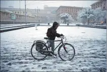  ?? MAX ROSSI / REUTERS ?? A man pushes his bicycle during heavy snow early in the morning in Rome, Italy, on Monday.