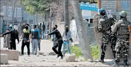  ??  ?? Kashmiri youths take on security forces during elections in Srinagar on Sunday.