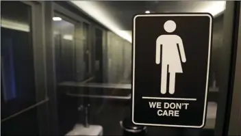  ?? AP PHOTO/GERRY BROOME ?? In this 2016 file photo, gender free sign hangs outside a restroom at 21c Museum Hotel in Durham, N.C.