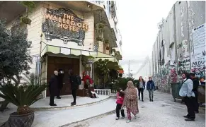  ??  ?? People pass by the The Walled Off Hotel in the West Bank city of Bethlehem. It was named Art Hotel of the Year in the Leading Culture Destinatio­ns Awards. — AP