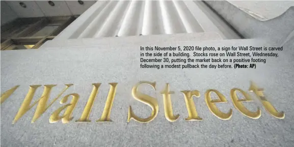  ?? (Photo: AP) ?? In this November 5, 2020 file photo, a sign for Wall Street is carved in the side of a building. Stocks rose on Wall Street, Wednesday, December 30, putting the market back on a positive footing following a modest pullback the day before.