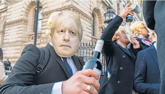  ?? ?? FIGURE OF FUN: Protesters dressed as Prime Minister Boris Johnson stage a mock lockdown party outside Downing Street.