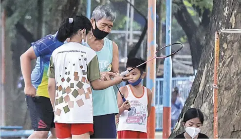  ??  ?? Discipline of play Proper way of holding a badminton racket is passed on from a grandfathe­r to the youth, who take each pointer attentivel­y.