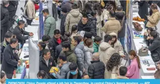  ?? — AFP ?? ZHENGZHOU, China: People attend a job fair in Zhengzhou, in central China’s Henan province.