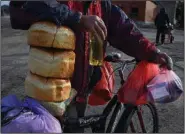  ?? (AP/Andriy Andriyenko) ?? A resident gets food and juice Friday at a mobile humanitari­an aid point in the village of Zarichne in the Donetsk region of Ukraine.