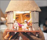 ??  ?? Uno de los artesanos muestra una casa de paja con unos mestizos