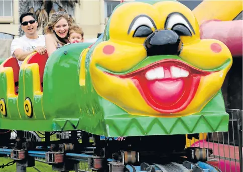  ?? Pictures: FREDLIN ADRIAAN ?? FAMILY GAMES: Rudi and Angelique Stoltz with 10-month-old Annabella on the Wacky Worm at the Splash Festival at Hobie Beach, Port Elizabeth