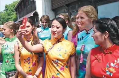  ?? DONG XUMING/ FOR CHINA DAILY ?? Women from different countries wear qipao, the traditiona­l Chinese dress, and pose for a selfie during the Hangzhou Global Qipao Festival in Zhejiang province on Friday.