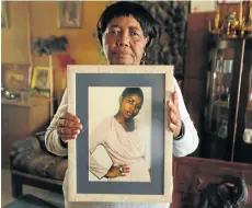  ?? Kevin Sutherland Picture: ?? Sizakele Simelane with a portrait of her daughter Nokuthula, in Bethal, Mpumalanga, in 2013. Nokuthula was abducted by apartheid security police more than 20 years ago, and her mother has been battling for justice ever since.