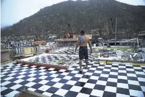  ?? AP ?? In this September 26, 2017 file photo, Nestor Serrano walks on the upstairs floor of his home, where the walls were blown off, in the aftermath of Hurricane Maria, in Yabucoa, Puerto Rico. Thousands of Puerto Ricans have been forced to drain their savings, close their businesses, or resign themselves to living with structural damage as they fight with insurance companies over storm claims.