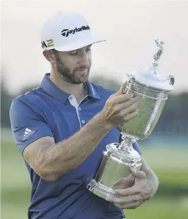  ?? JOHN MINCHILLO / THE ASSOCIATED PRESS ?? Dustin Johnson holds the trophy after winning the U. S. Open golf championsh­ip by three strokes on Sunday on the unforgivin­g links at Oakmont.