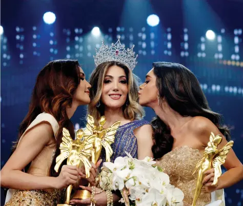  ?? REUTERS/SOE ZEYA TUN ?? Thailand’s Ruethaipre­eya Nuanglee and Brazil’s Ariella Moura kiss Mexico’s Valentina Fluchaire after she won crown at the final show of the Miss Internatio­nal Queen 2020 transgende­r beauty pageant in Pattaya, Thailand, March 7, 2020.