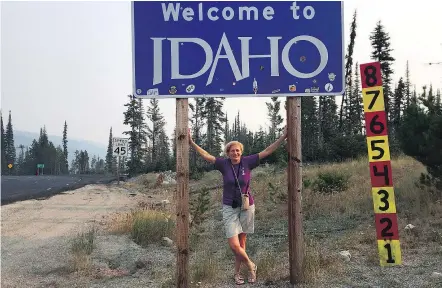  ?? — THE ASSOCIATED PRESS ?? Beth Harpaz standing beneath a Welcome to Idaho sign near Gibbonsvil­le, Idaho, and the Montana border. Idaho was Harpaz’s final destinatio­n on a quest to visit all 50 states.