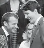  ??  ?? French President Emmanuel Macron, left, Foreign Affairs Minister Chrystia Freeland and Prime Minister Justin Trudeau share a light moment at the NATO summit.