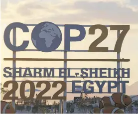  ?? Photo / AP ?? The sun sets behind signage for the COP27 UN Climate Summit in Sharm elSheikh, Egypt, yesterday. Envisage the summit as akin to a festival surrounded by fringe festivals and stalls selling things.