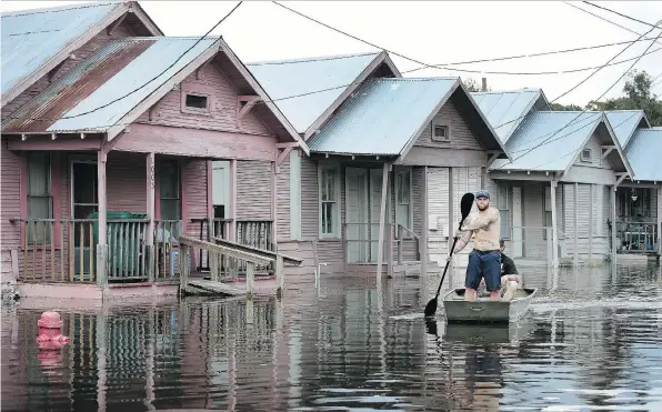  ?? SCOTT OLSON/GETTY IMAGES ?? Marine veteran Rocky Damico searches for residents in need of help after Harvey’s torrential rains caused widespread flooding on Saturday in Orange, Texas. The devastatio­n has sparked a debate over the climate and the need for tighter homebuildi­ng...