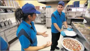  ??  ?? Pizza Pizza CEO Paul Goddard, right, on the front lines in Undercover Boss Canada.