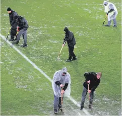  ??  ?? Race against time: Staff work on the pitch before kick-off
