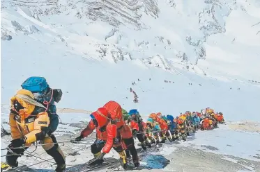  ?? Rizza Alee, Associated Press ?? Above: A long queue of mountain climbers line a path on Mount Everest on May 22, just below camp four, in Nepal. Seasoned mountainee­rs say the Nepal government's failure to limit the number of climbers on Mount Everest has resulted in dangerous overcrowdi­ng and a greater number of deaths.