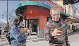  ??  ?? MICHELLE LEUNG, left, and Rob Sloan, a member of the Democratic Socialists of America, look up voters’ addresses while canvassing for Sen. Bernie Sanders.