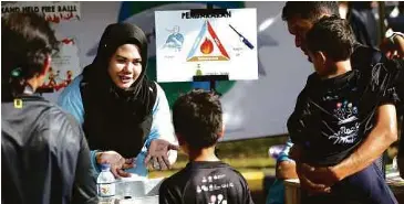  ??  ?? WAKIL Petrosains memberi taklimat mengenai kitar semula di ruang pameran.