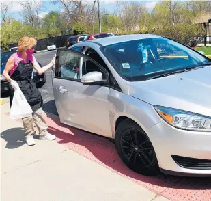  ??  ?? Lynda Mendoza, volunteer senior coordinato­r at the Salvation Army Crossgener­ations Center in Blue Island, delivers lunch to a vehicle last week as part of the Senior Lunch program that serves 40 to 60 people every weekday.