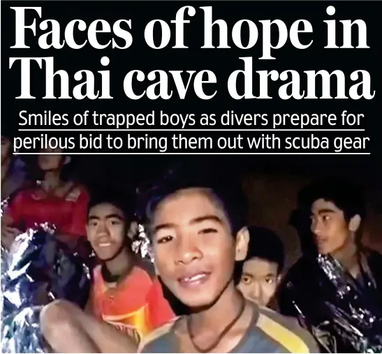  ??  ?? We’re OK: Members of the trapped football team smile for the camera in footage taken by Thai special forces divers yesterday