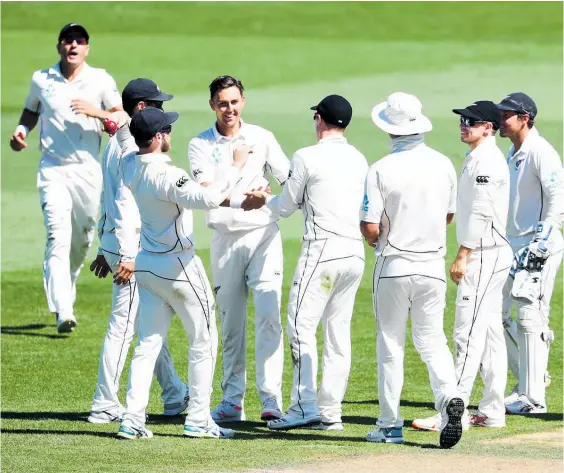  ??  ?? Trent Boult is congratula­ted by teammates after claiming the wicket of Liton Das yesterday.