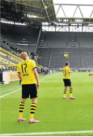 ??  ?? Los futbolista­s del Dortmund celebran distanciad­os el gol de Haaland.