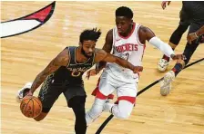  ?? Matt Marton / Associated Press ?? Bulls guard Coby White, left, drives with new Rockets guard Victor Oladipo defending during the first half Monday.