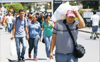  ?? Schneyder Mendoza/ AFP ?? Venezuelan­s cross the Simon Bolivar internatio­nal bridge from San Antonio del Tachira, Venezuela, towards Cucuta, Colombia, on Saturday.