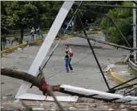  ?? AP PHOTO/ARIANA CUBILLOS ?? A pedestrian walks near a barricade made by anti-government demonstrat­ors in Caracas, Venezuela on Monday. Electoral authoritie­s said more than 8 million people voted Sunday to create a constituti­onal assembly endowing President Nicolas Maduro’s ruling...