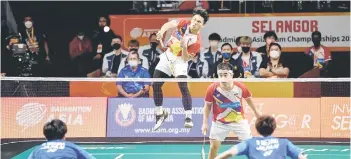  ?? — Bernama photo ?? Malaysia’s Nur Izzuddin Mohd Rumsani smashes as Goh Sze Fei looks on during the men’s doubles Group B match against Japan’s Mezaki Shuntaro and Nishida Haruya.