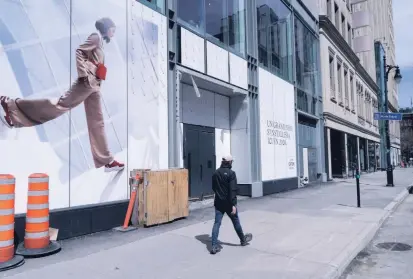  ?? PAUL CHIASSON THE CANADIAN PRESS ?? A man walks along a near-empty Sainte-Catherine Street in Montreal on Tuesday. Quebec is Canada’s hardest-hit province.