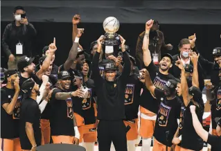  ?? Jae C. Hong / Associated Press ?? Phoenix Suns head coach Monty Williams hoists the Western Conference trophy as he and his players celebrate after defeating the Los Angeles Clippers in Game 6 at Staples Center.