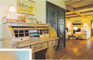  ??  ?? In the anteroom located in the left section of the home, an antique oak wood rolltop desk stands next to a recessed wardrobe hidden behind black stained doors.